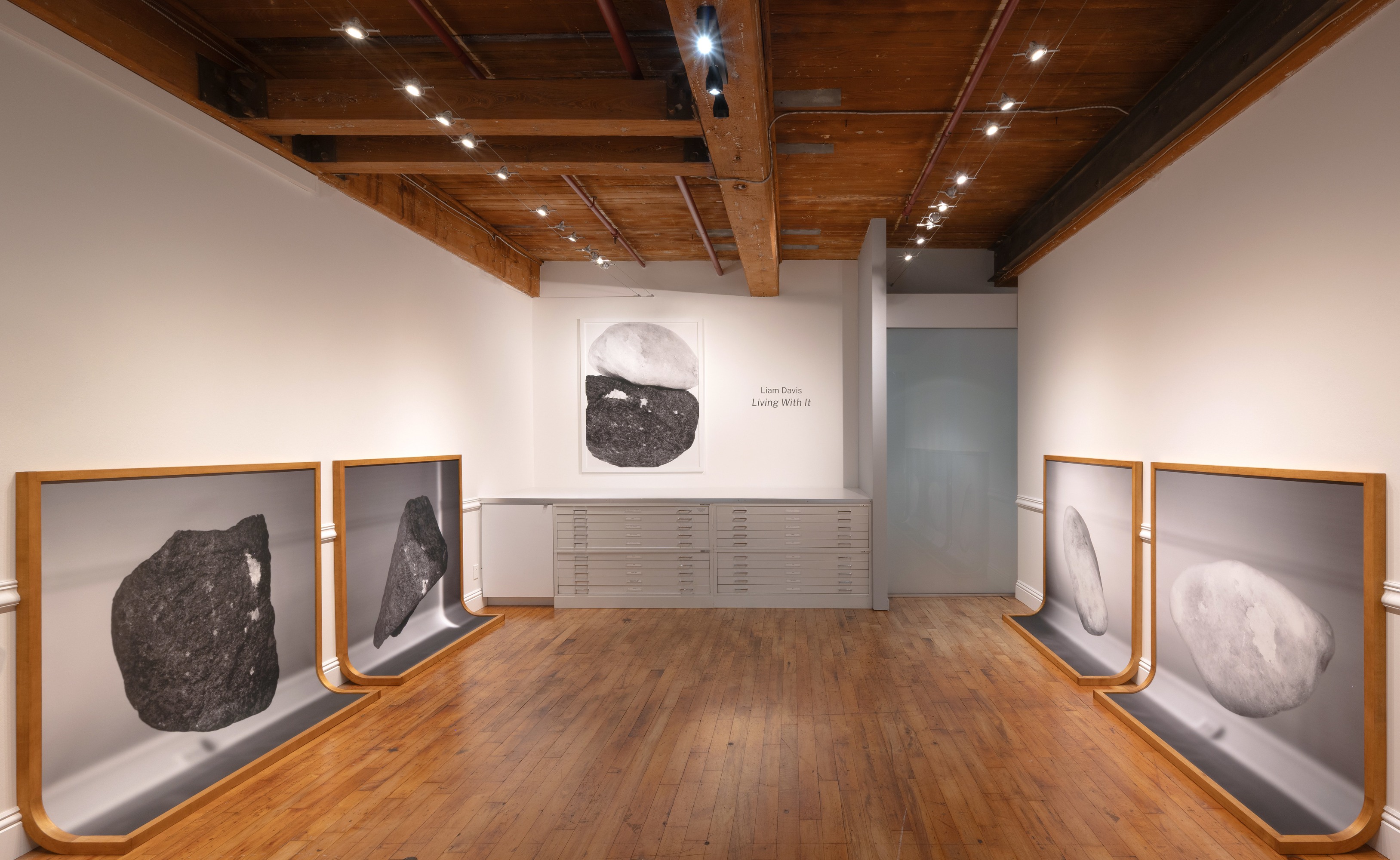 Six framed prints curving to become the floor and the wall. One flat photographic print of two rocks touching