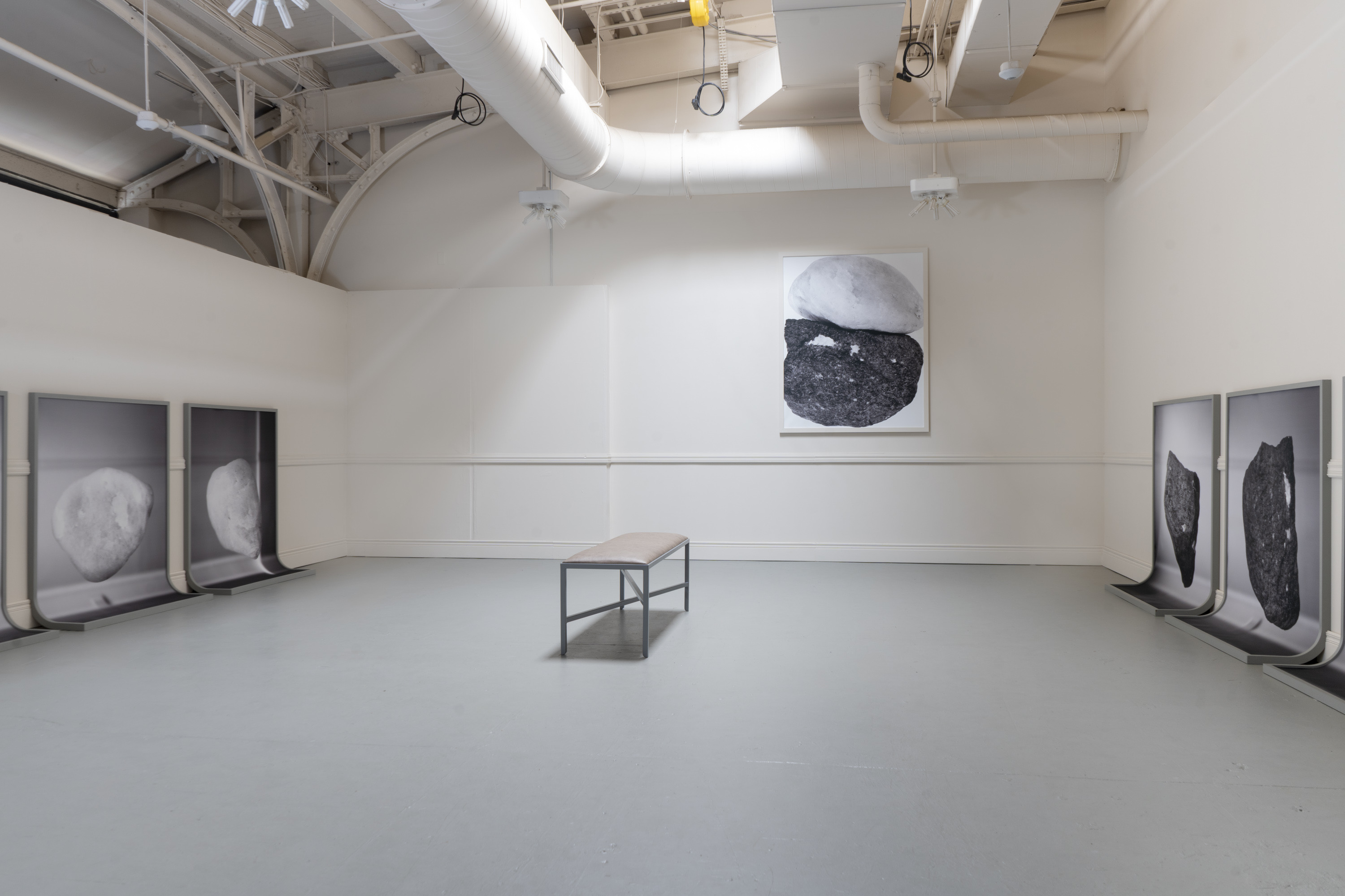 Six framed prints curving to become the floor and the wall. One flat photographic print of two rocks touching