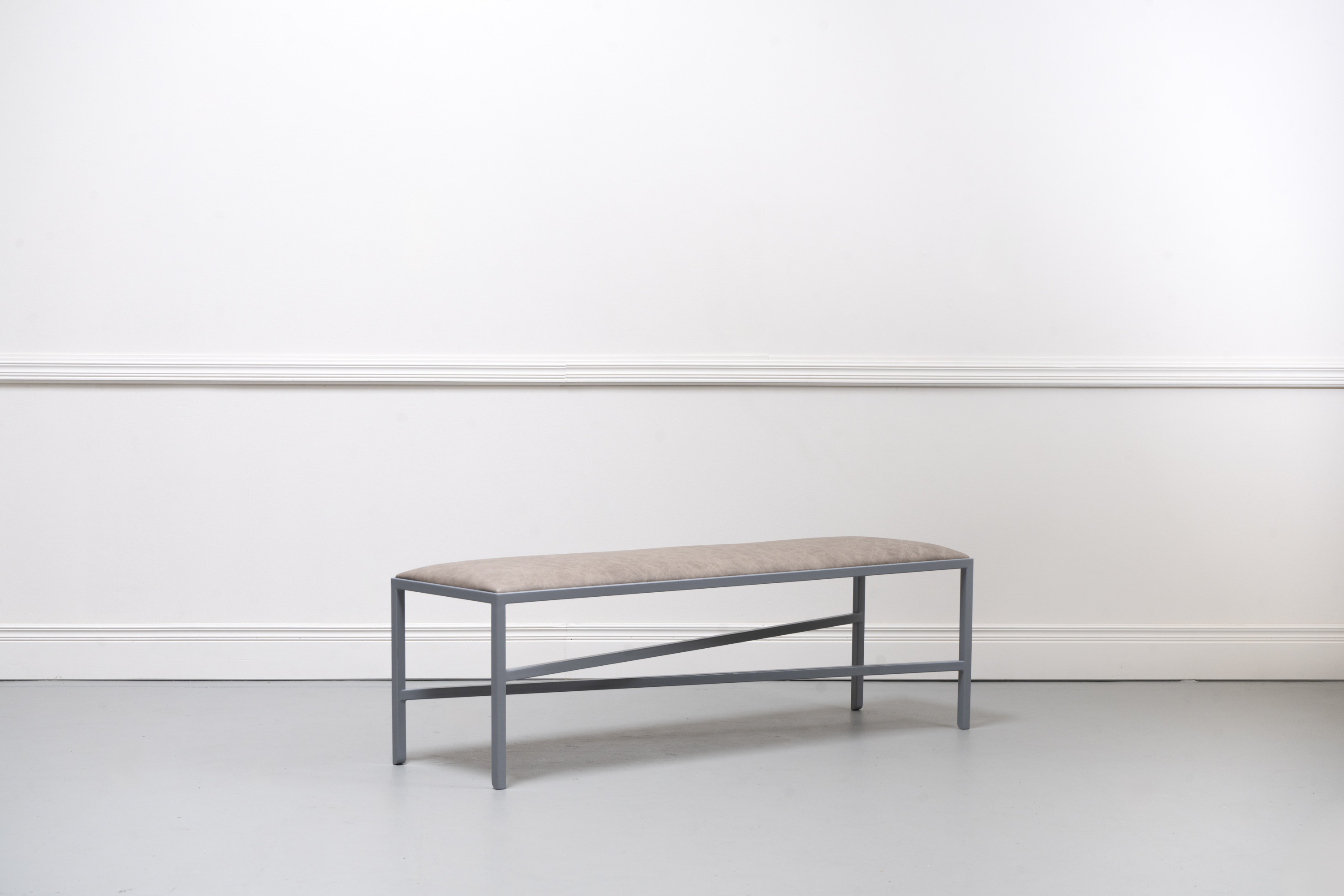 steel and leather gallery bench on tip toes for sitting on while looking at things